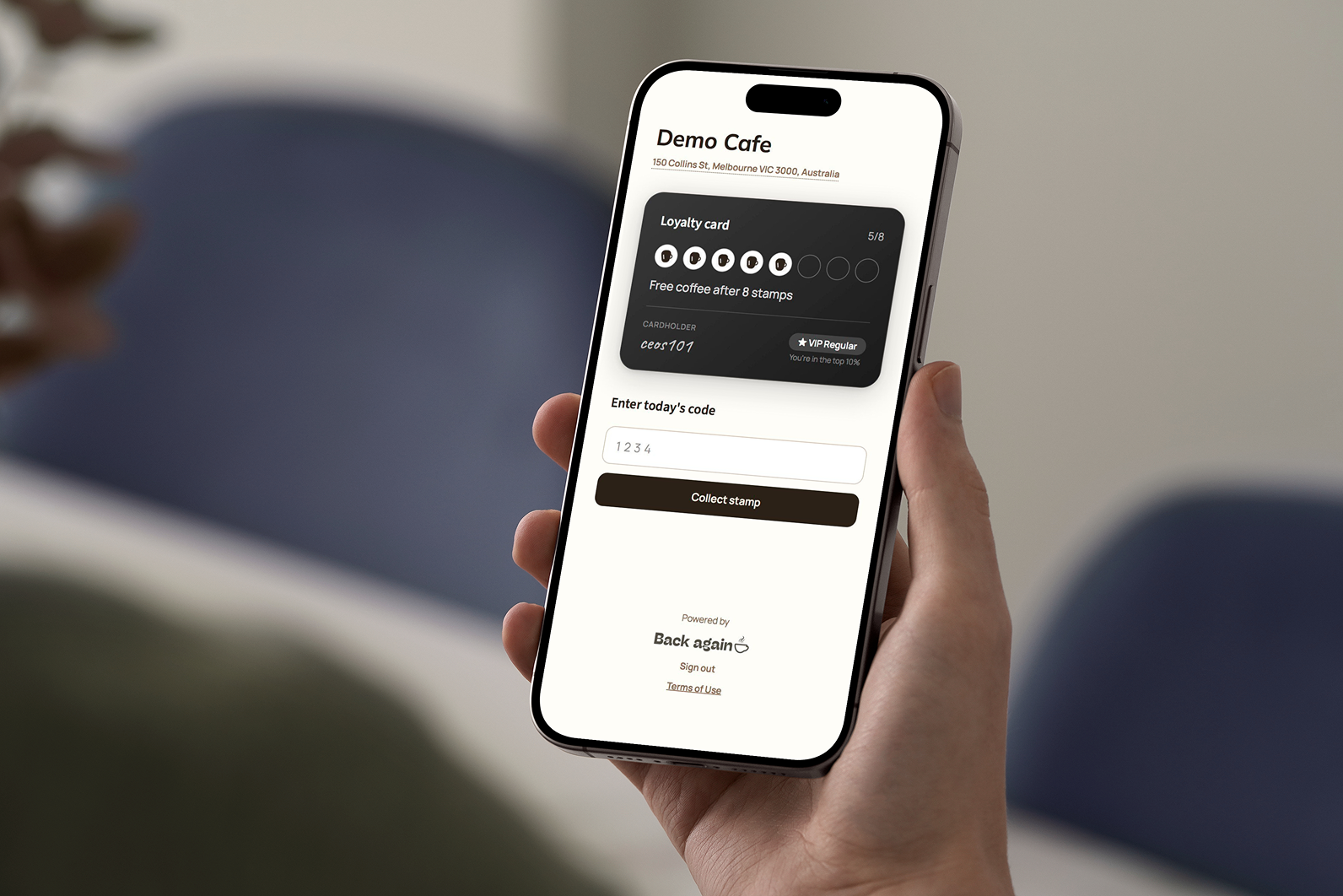 Customer holding phone with Back Again digital loyalty card on screen